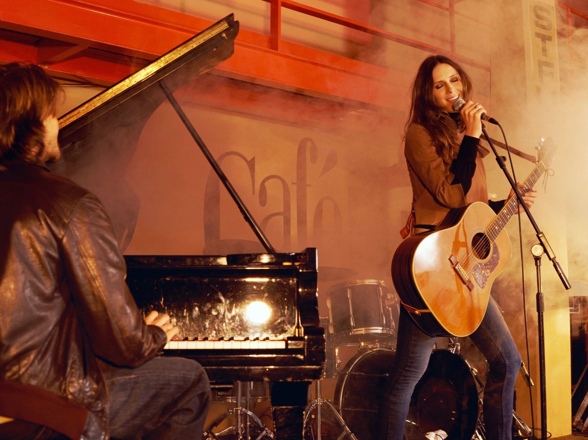 A man with long hair is playing guitar