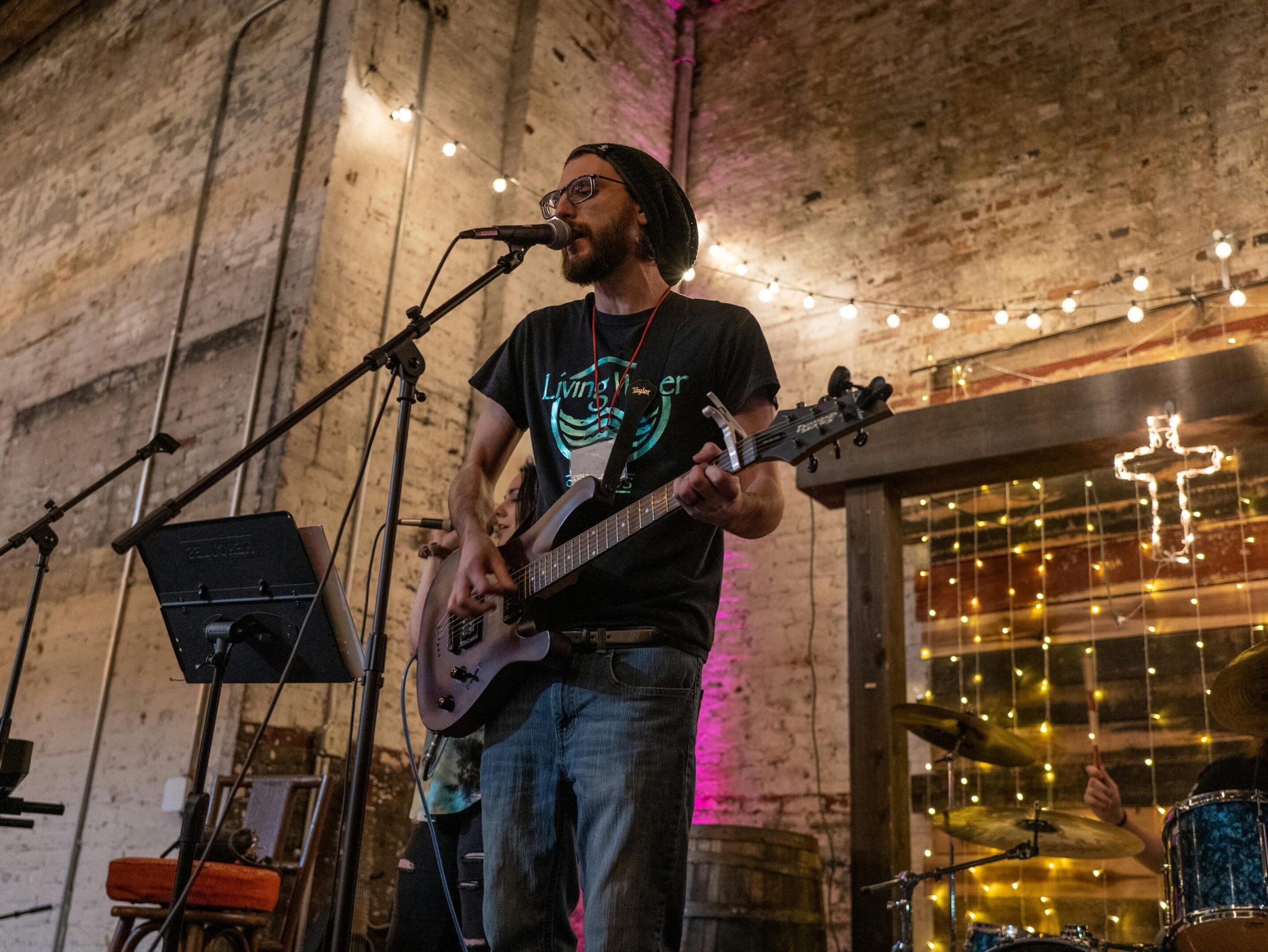 A man with a beard and glasses playing guitar