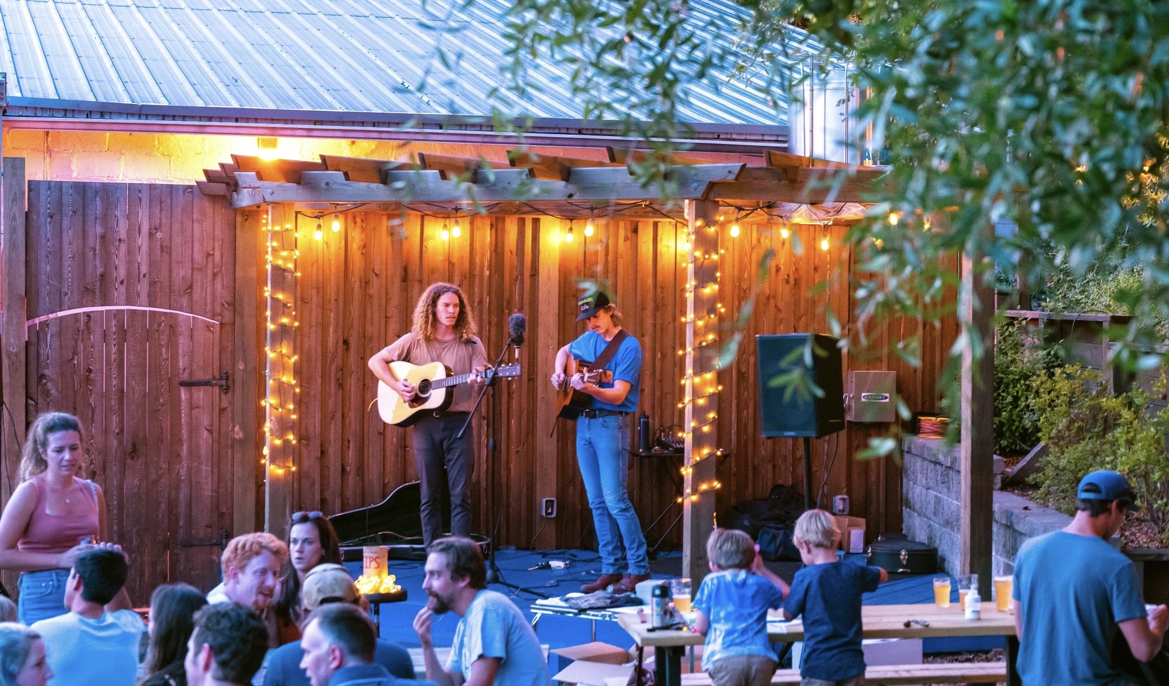 Acoustic musicians performing live at an outdoor restaurant in Oceanside, California during an evening concert.