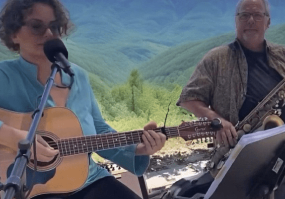 Two people are playing guitar and singing.