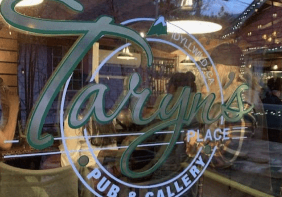 A restaurant window with the name taryn 's place written in it.